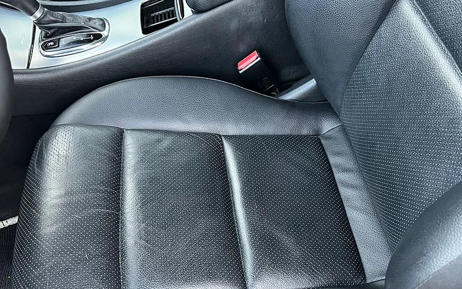 Interior delantero de un coche, asientos y consola limpios por dentro.