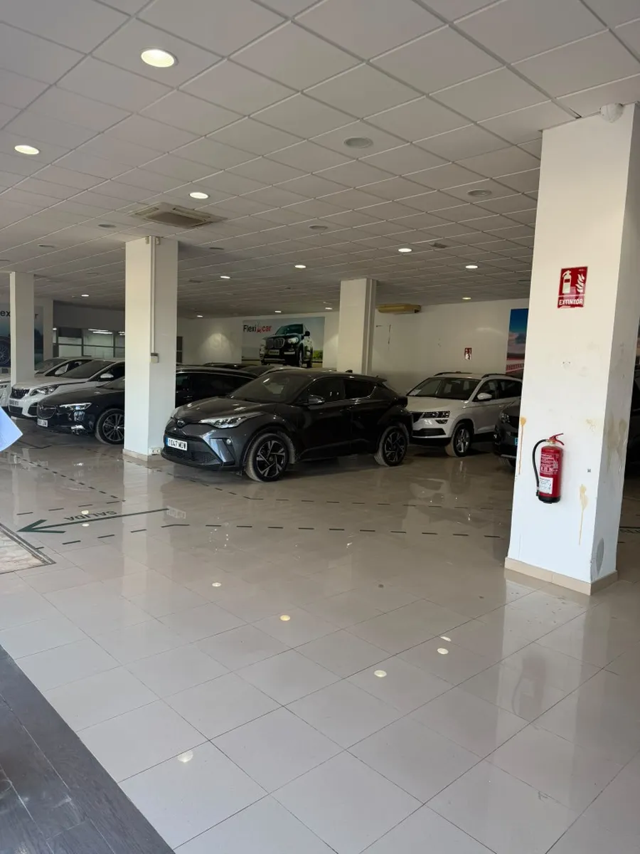 Después: concesionario y oficinas con suelo completamente limpio, brillante y coches aparcados.