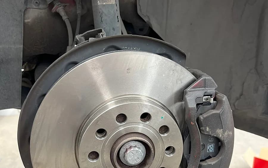 Disco de freno y pinza nuevos, recién montados en la rueda.
