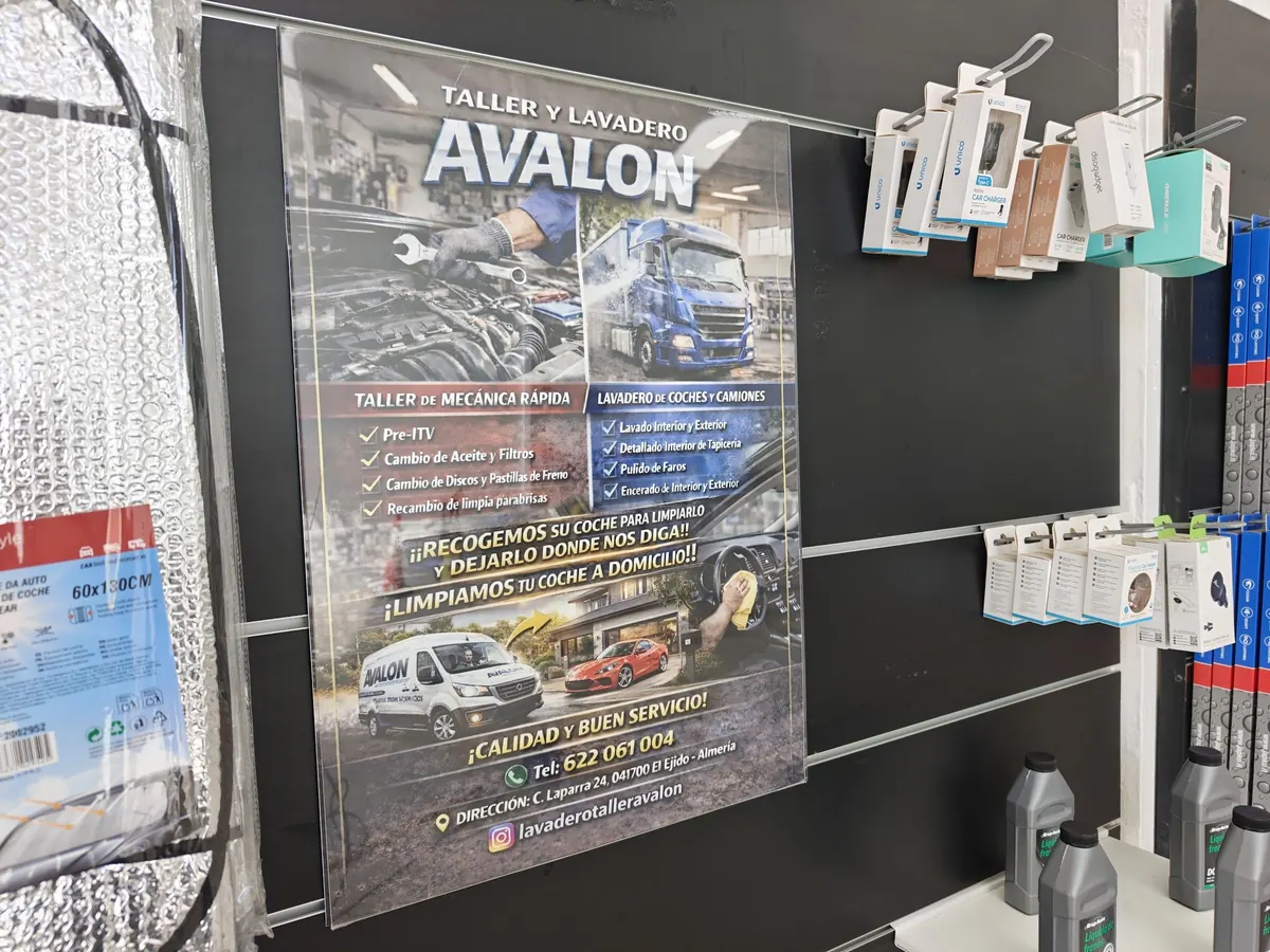 Estantería con recambios y consumibles del taller, junto al cartel con los servicios de mecánica rápida.